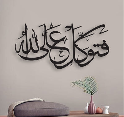 Living room with Arabic calligraphy wall decal, sofa, and small table with decor items.